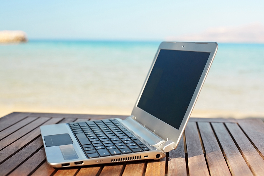 Close-up of laptop on table on the beach